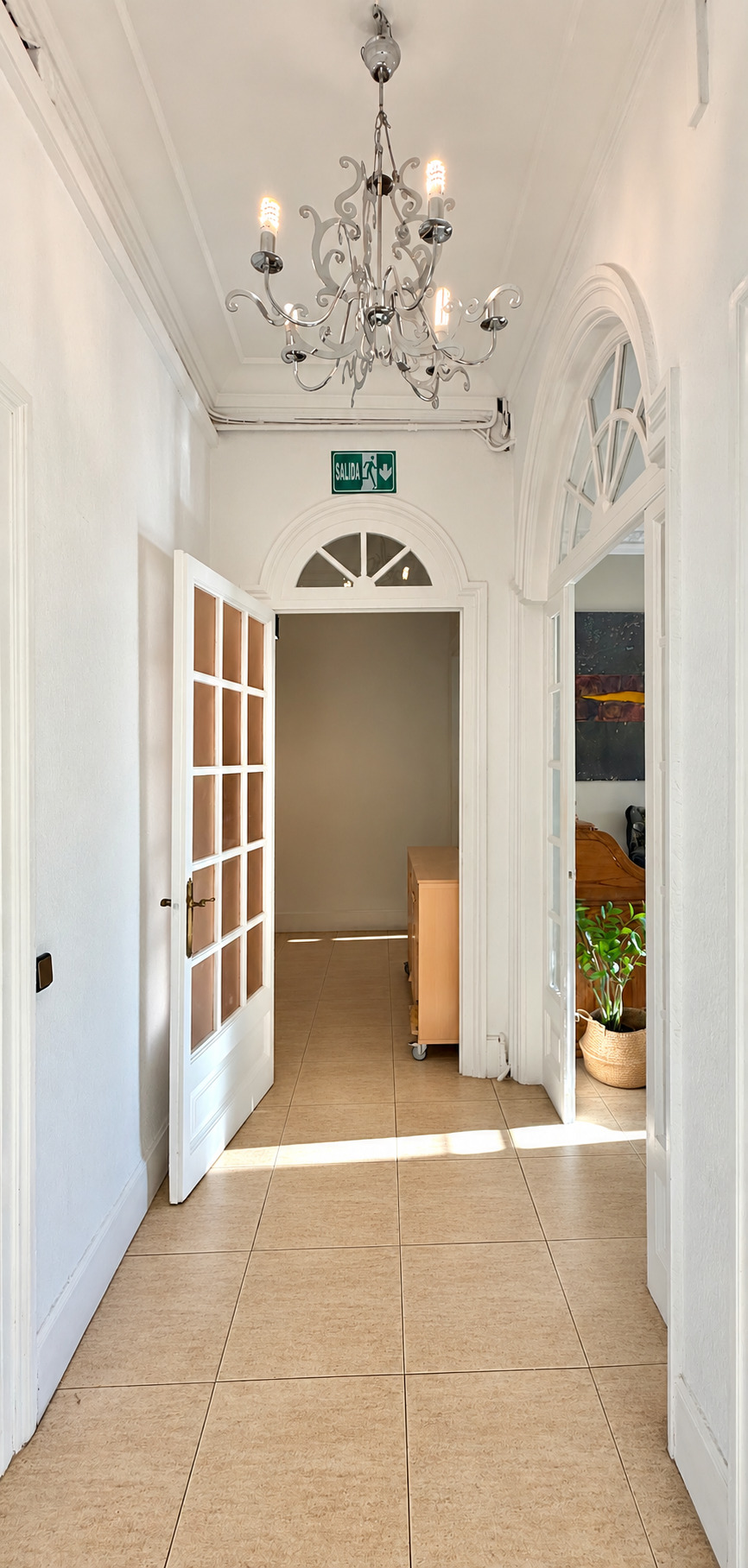 Pasillo elegante con salida y candelabro